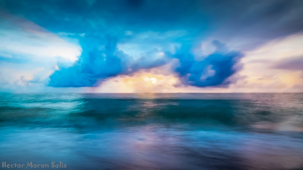 Expressionist seascape by Héctor Morón: dramatic storm clouds break over a dark sea, with light piercing the horizon