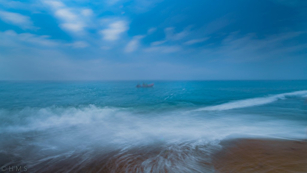 The Boatman, abstract seascape fine art photography with intentional camera movement (ICM); solitary figure on a boat dissolving into waves and light