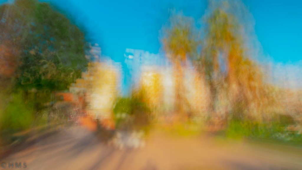 Abstract ICM photograph of a Mediterranean park, soft textures of green and golden light blending through trees and paths — fine art impressionist style by Héctor Morón